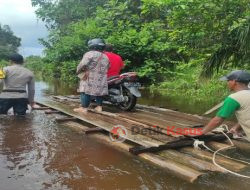 Bhabinkamtibmas Polsek Boyan Tanjung,  Bantu Pengendara Sepeda Motor Melewati Jalan yang Terendam Banjir